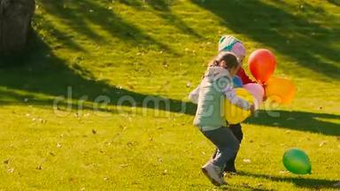 小女孩拿着气球在踢另一个绿色气球